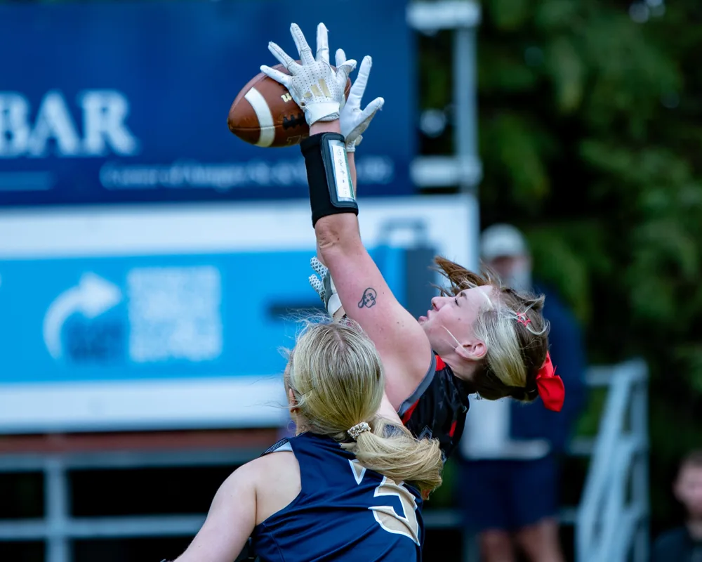 South Dublin Panthers and Dublin Redbows players reach overhead for the ball.