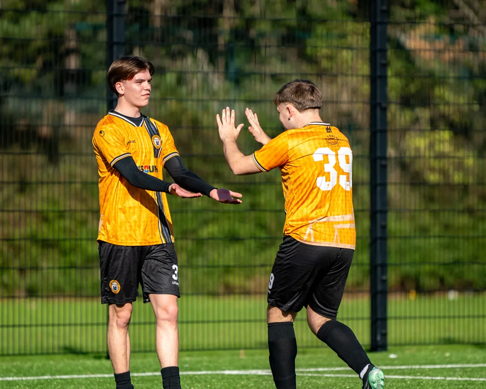 Teammates exchange a celebration. H&W Welders Reserves v Warrenpoint Reserves.