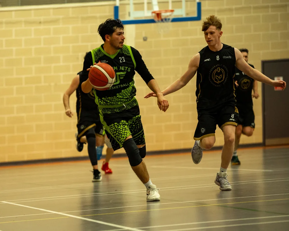 An Antrim Jets ball carrier dribbles towards a Magherafelt Titans defender.