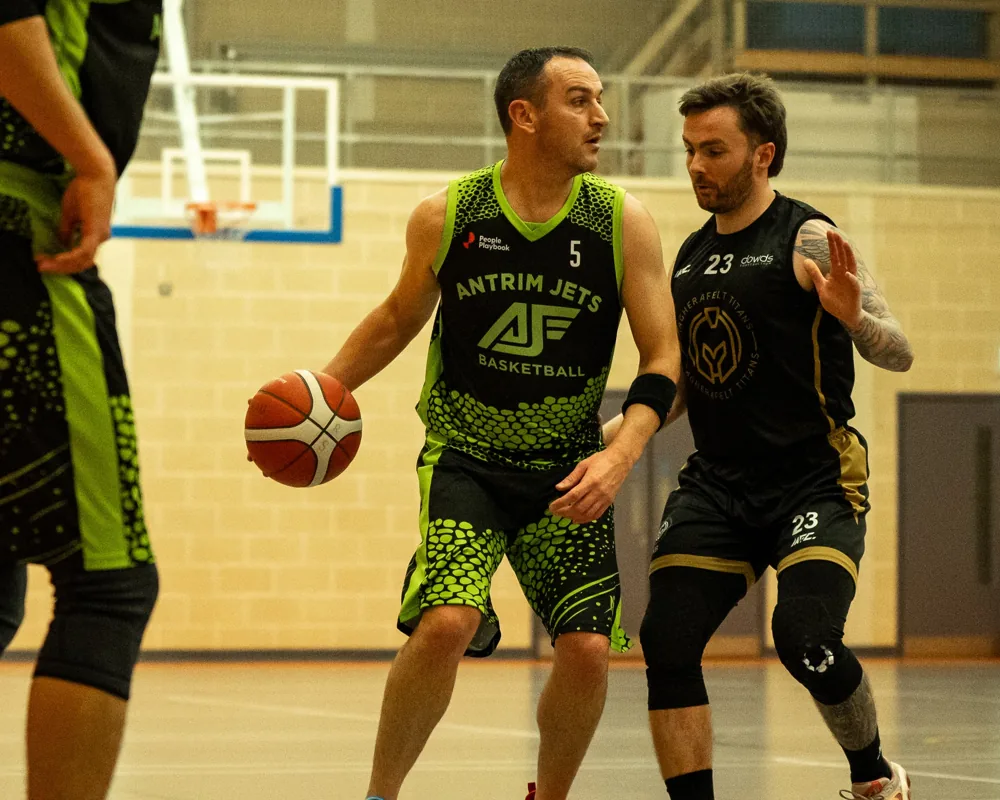 An Antrim Jets player shields the ball from a Magherafelt Titans defender.