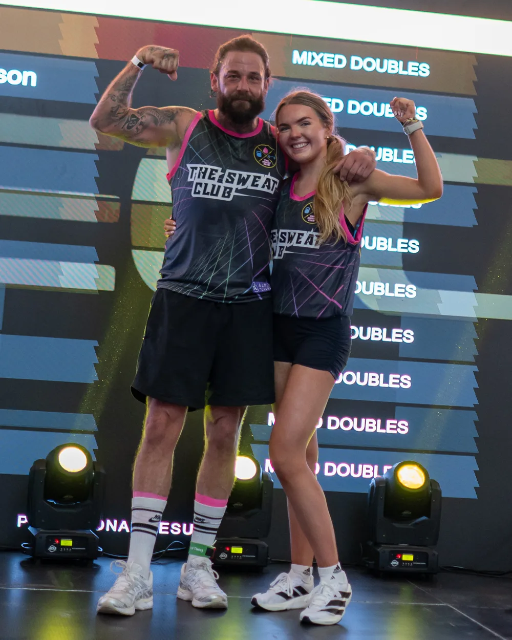 Competitors pose with arms raised. Mecca Sim 5.