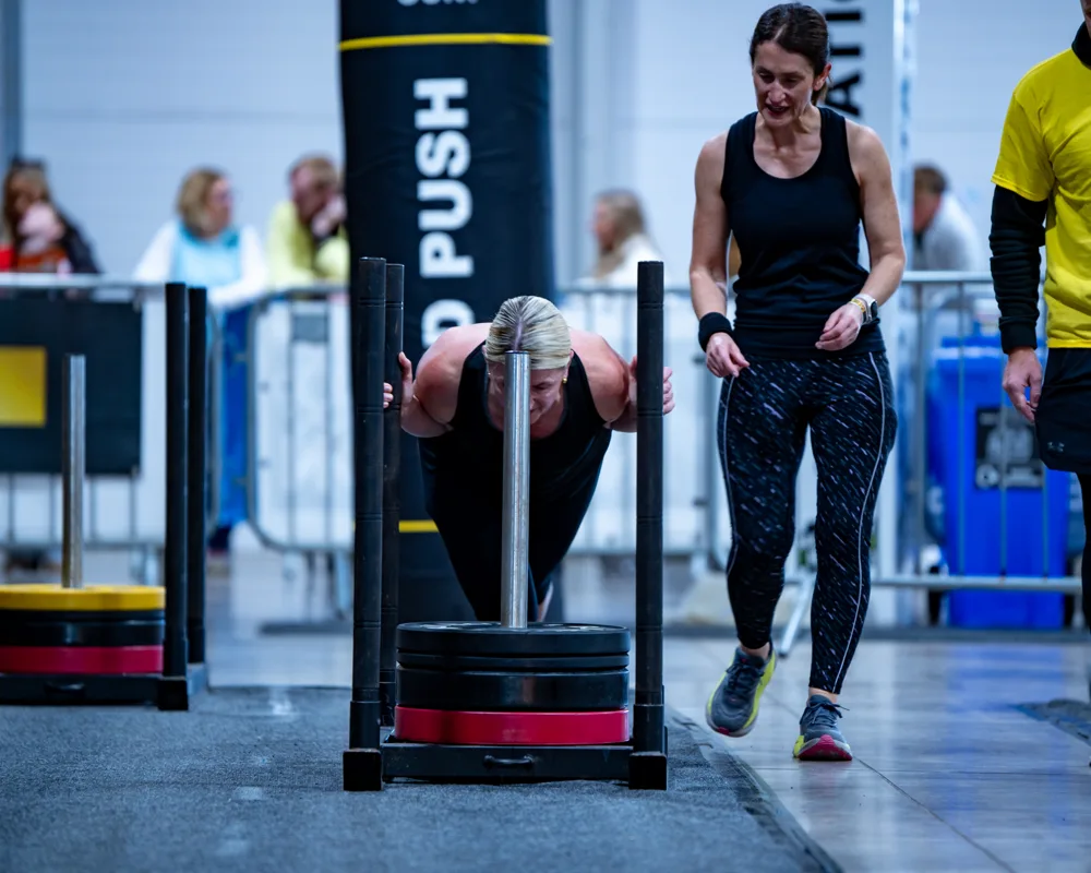 Athletes push weighted sleds. Mecca Sim 5.