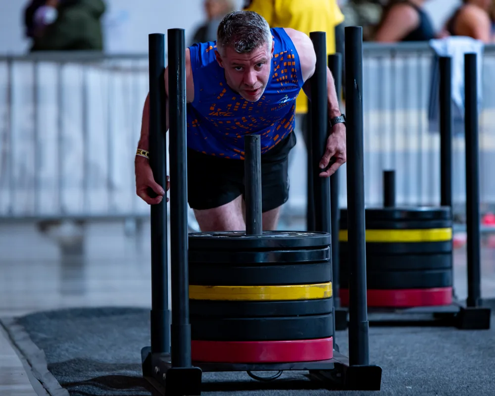 Athlete pushes a weighted sled. Mecca Sim 5.