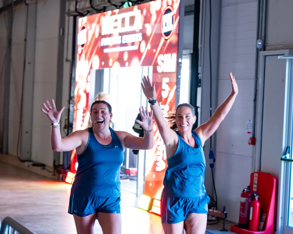 Competitors raise their arms. Mecca Sim 5.