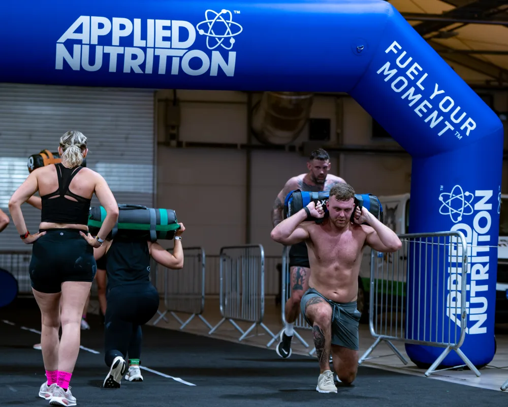 Athletes run beneath the event arch. Mecca Sim 5.