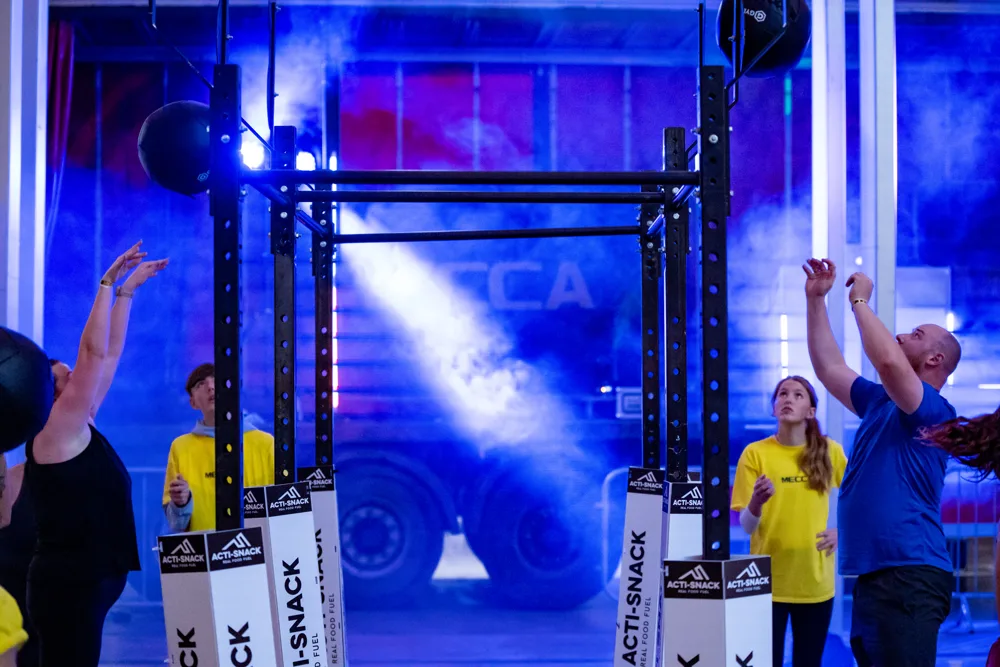 Athlete performs a wall-ball movement. Mecca Sim 5.
