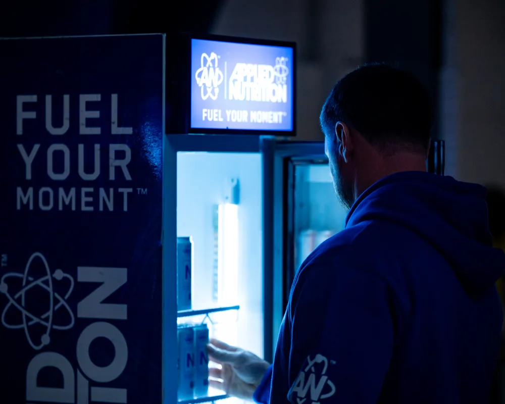 Competitor rests beside event signage. Mecca Sim 5.