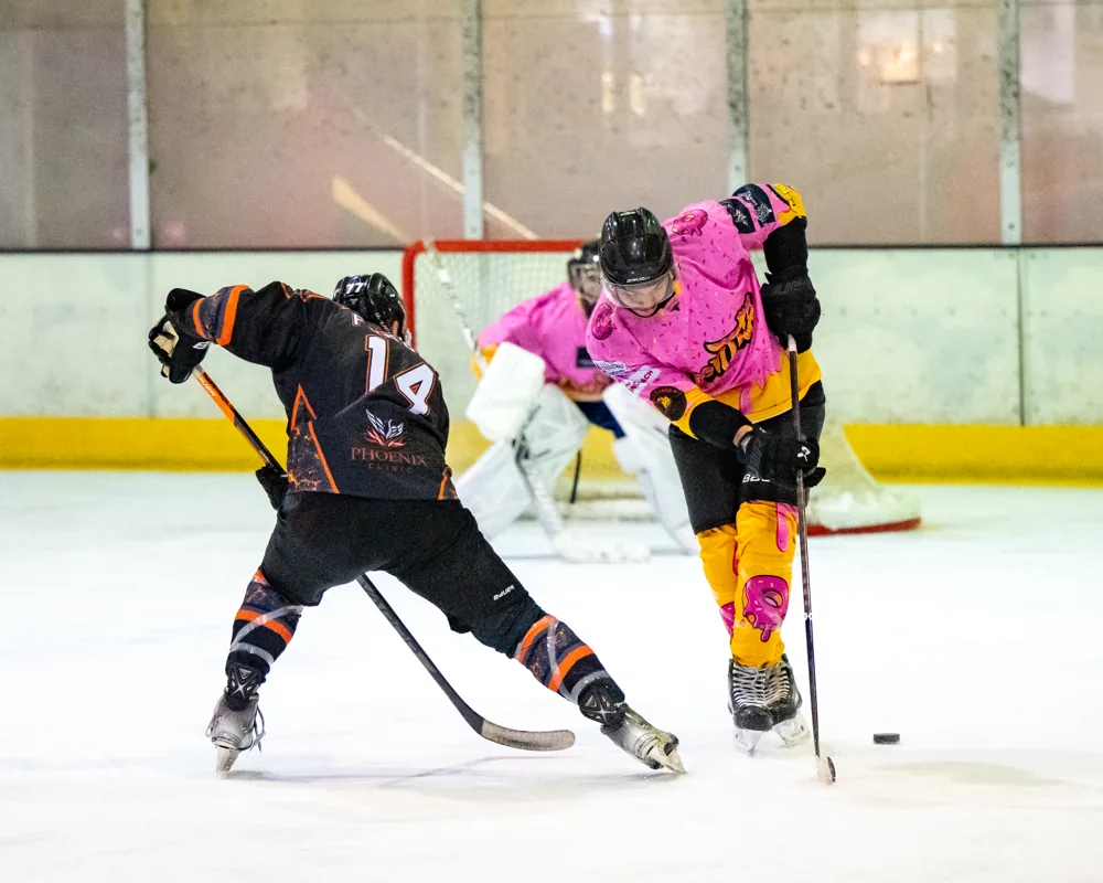 Phoenix number 14 battles a Donuts player for the puck in a spray of ice