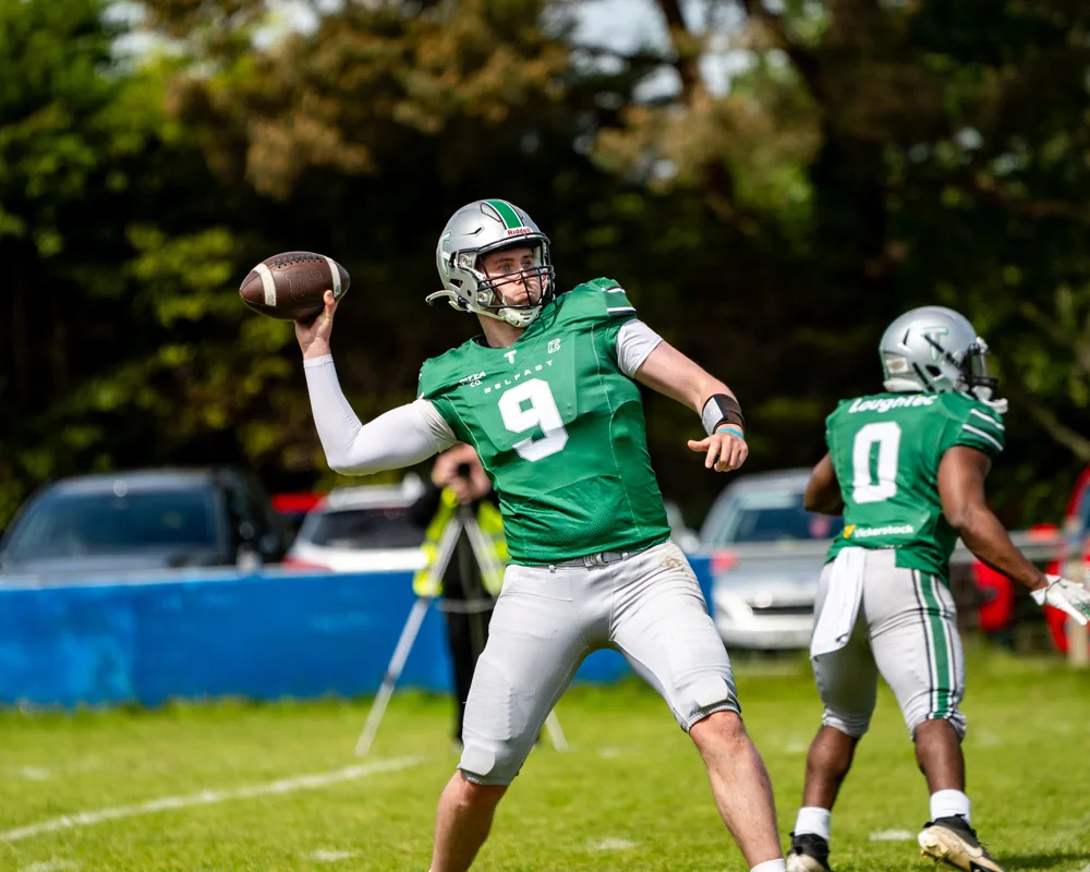 Belfast Trojans quarterback raises the ball to throw a pass.
